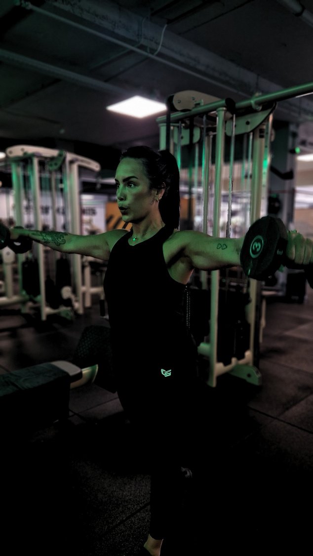 Stacey traint met dumbbells in de sportschool